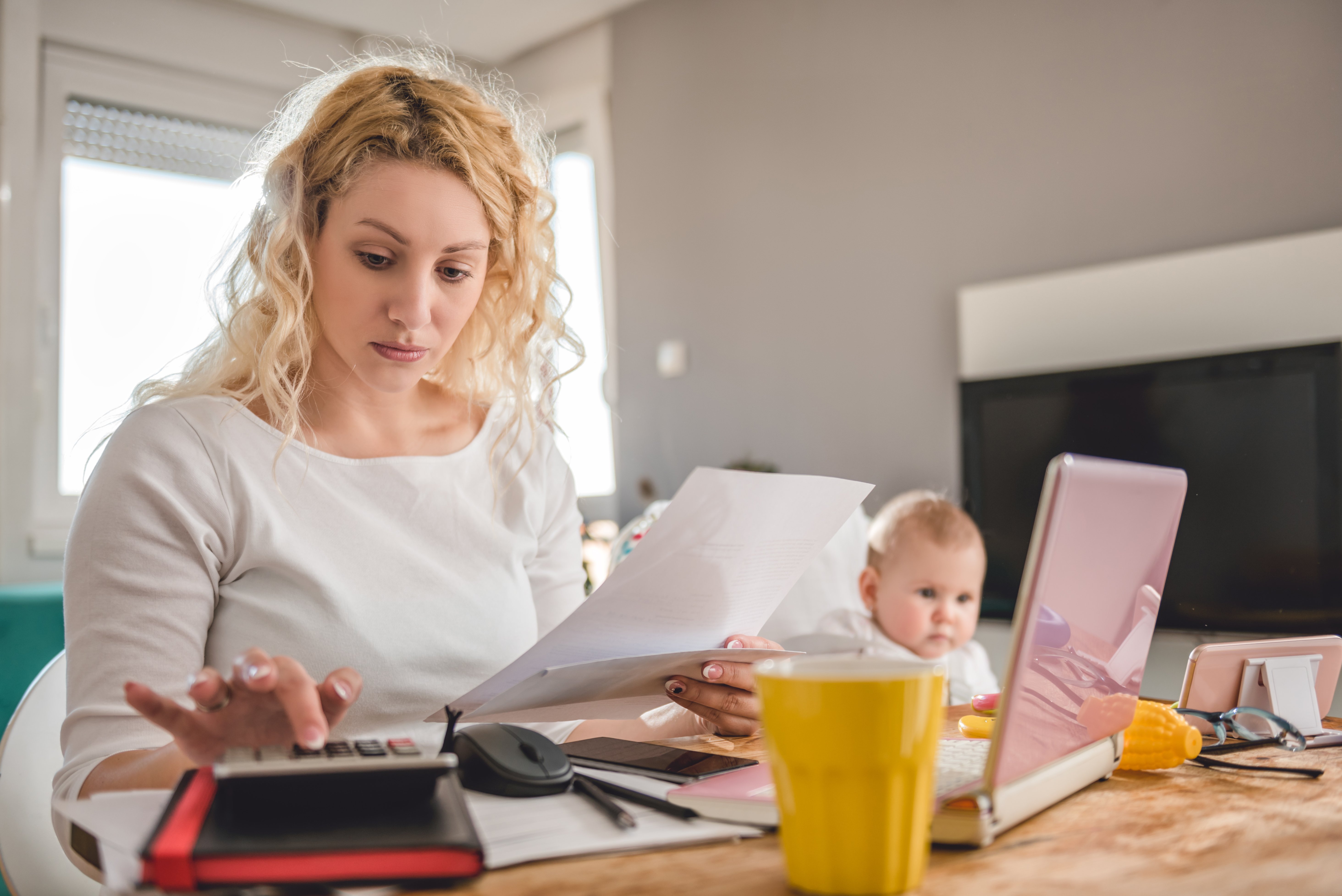 Žena s dítětem drží při počítání kus papíru | Zdroj: Shutterstock