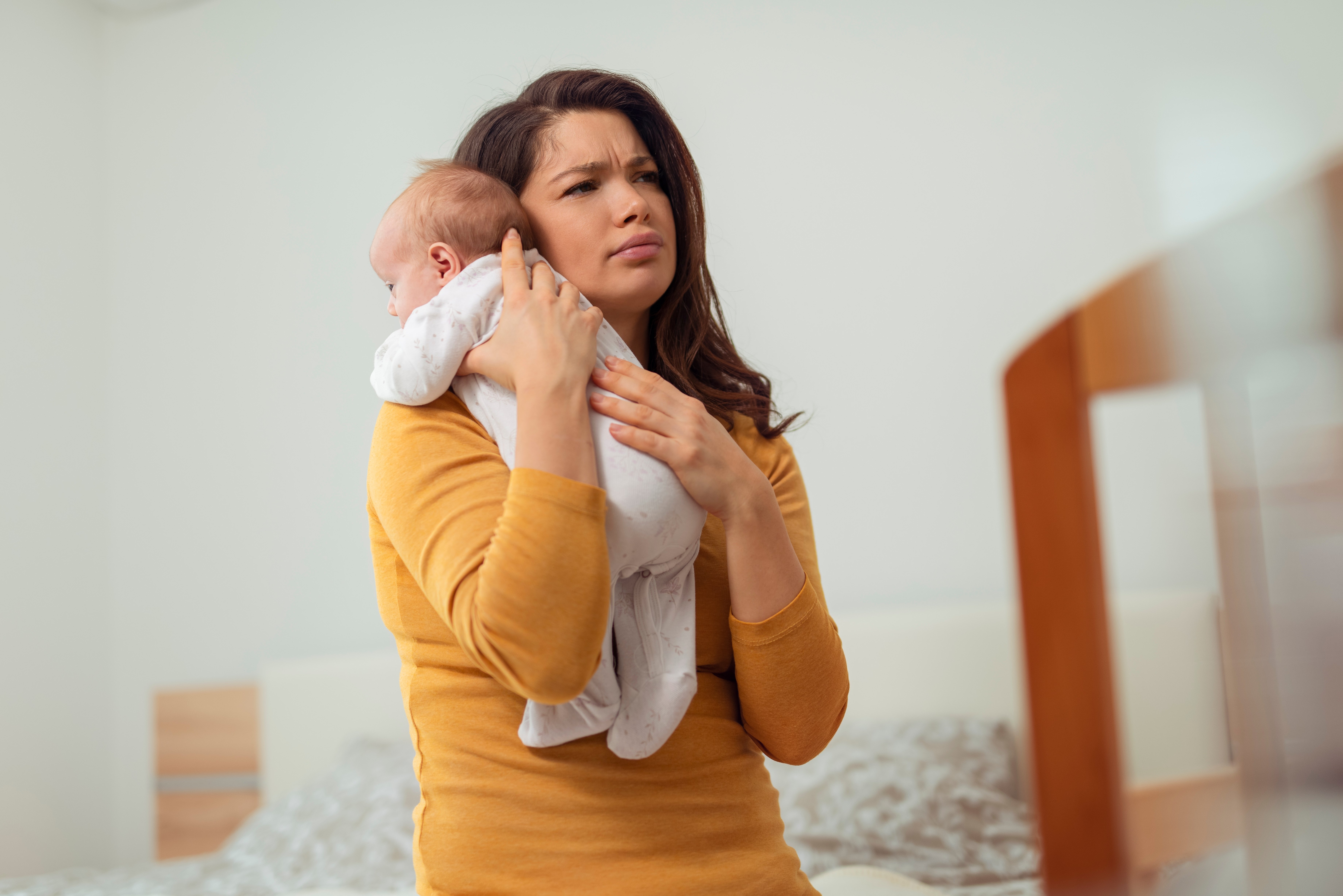 Žena vypadá unaveně, když drží dítě | Zdroj: Shutterstock