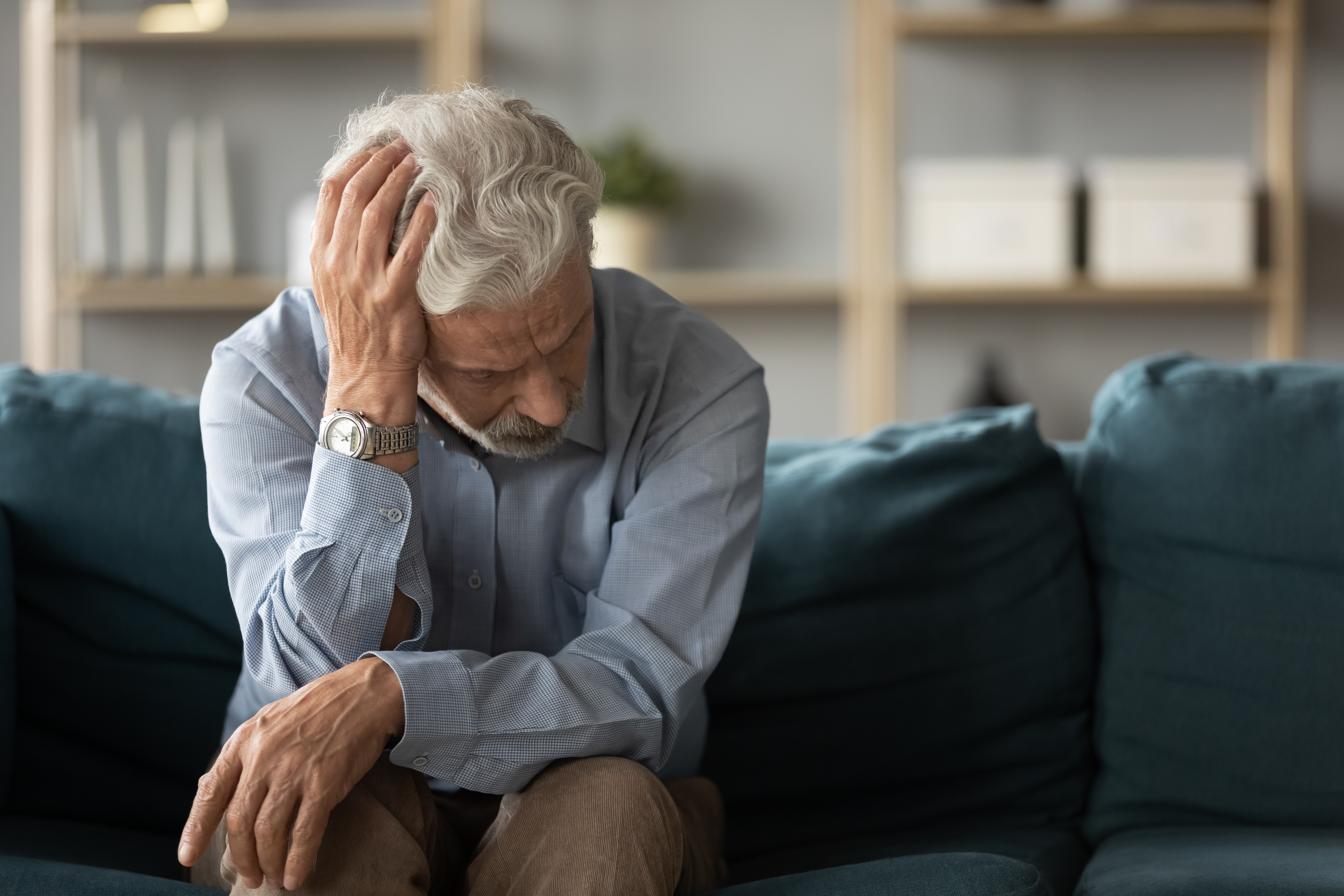 Starý muž, který se držel za hlavu a vypadal rozrušeně | Zdroj: Shutterstock