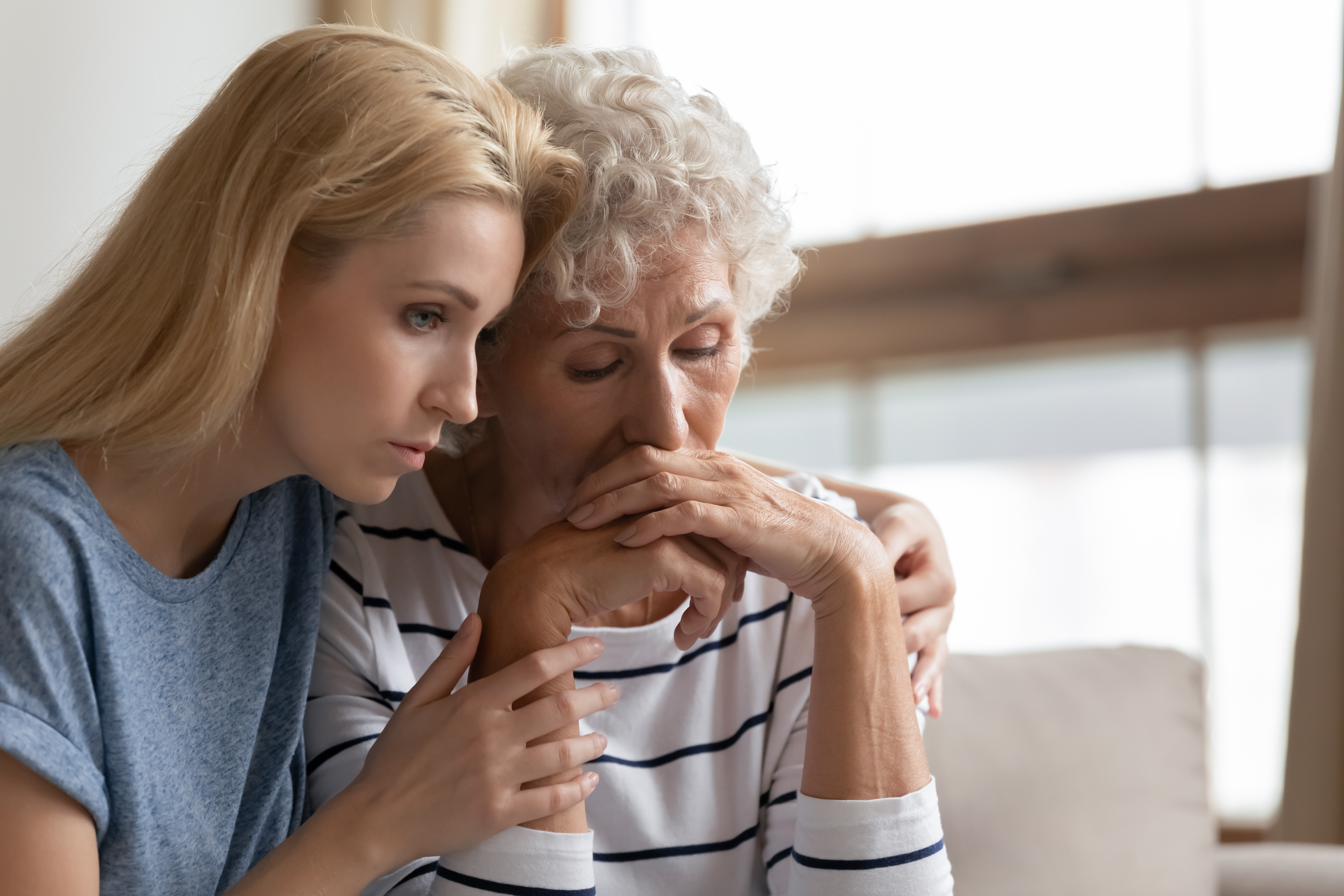 Mladá žena utěšující starší dámu | Zdroj: Shutterstock